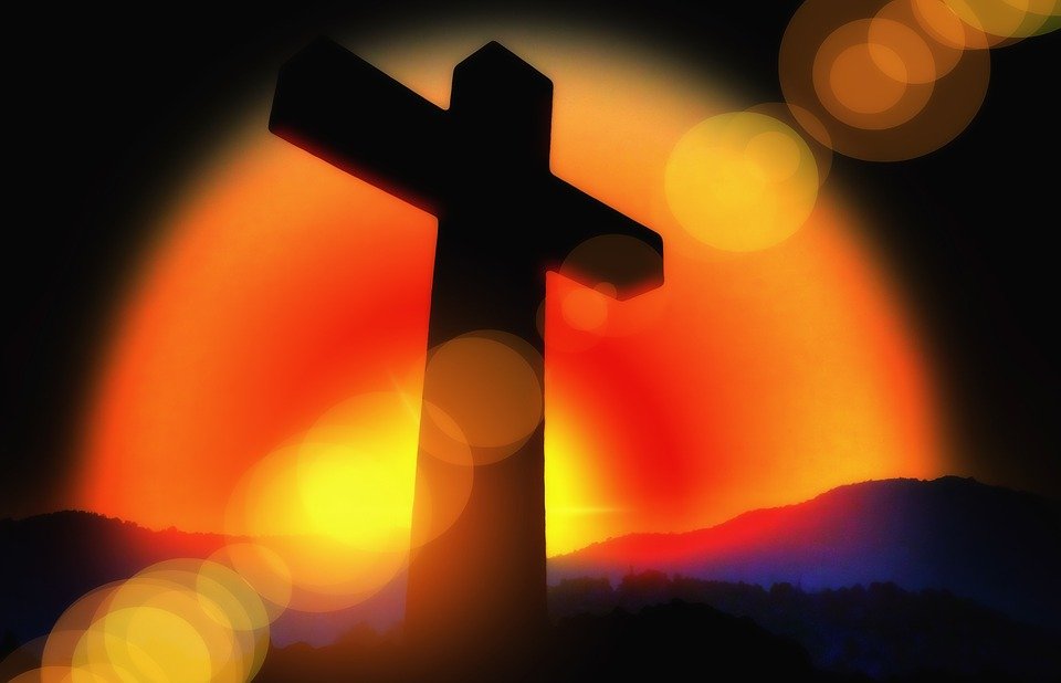 Cross silhouette with orange and red light
